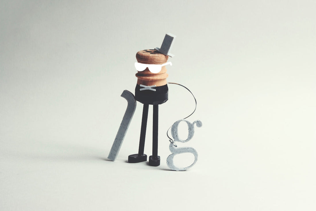 A whimsical character with a cane and letter 'g' accessory.